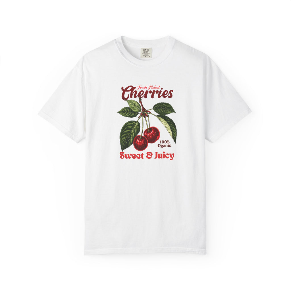 White heavyweight relaxed-fit T-shirt featuring a vintage-style botanical illustration of red cherries with green leaves and retro red script reading "Fresh Picked Cherries" and "Sweet & Juicy" on a plain background — Studio DeLuz graphic tee.