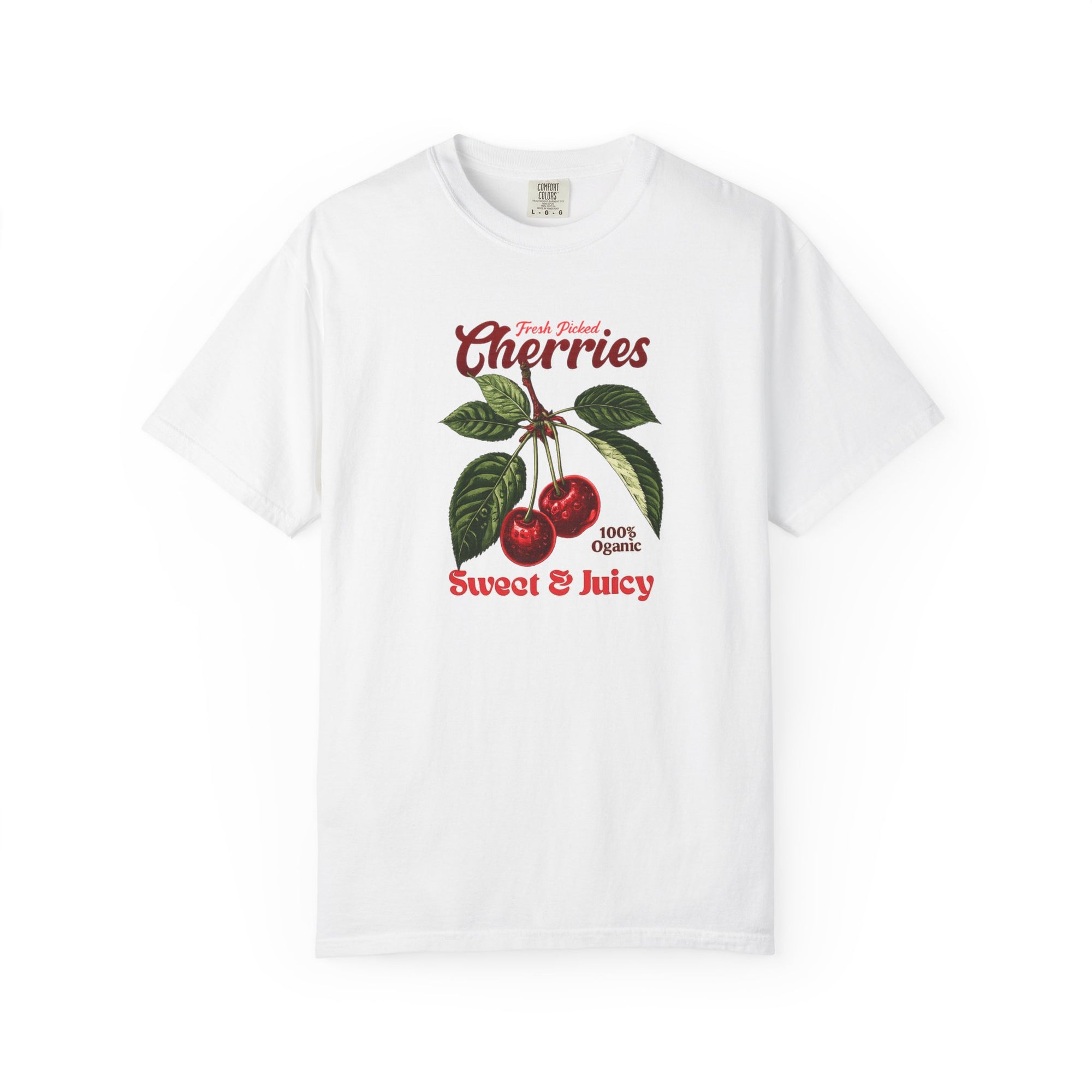 White heavyweight relaxed-fit T-shirt featuring a vintage-style botanical illustration of red cherries with green leaves and retro red script reading "Fresh Picked Cherries" and "Sweet & Juicy" on a plain background — Studio DeLuz graphic tee.